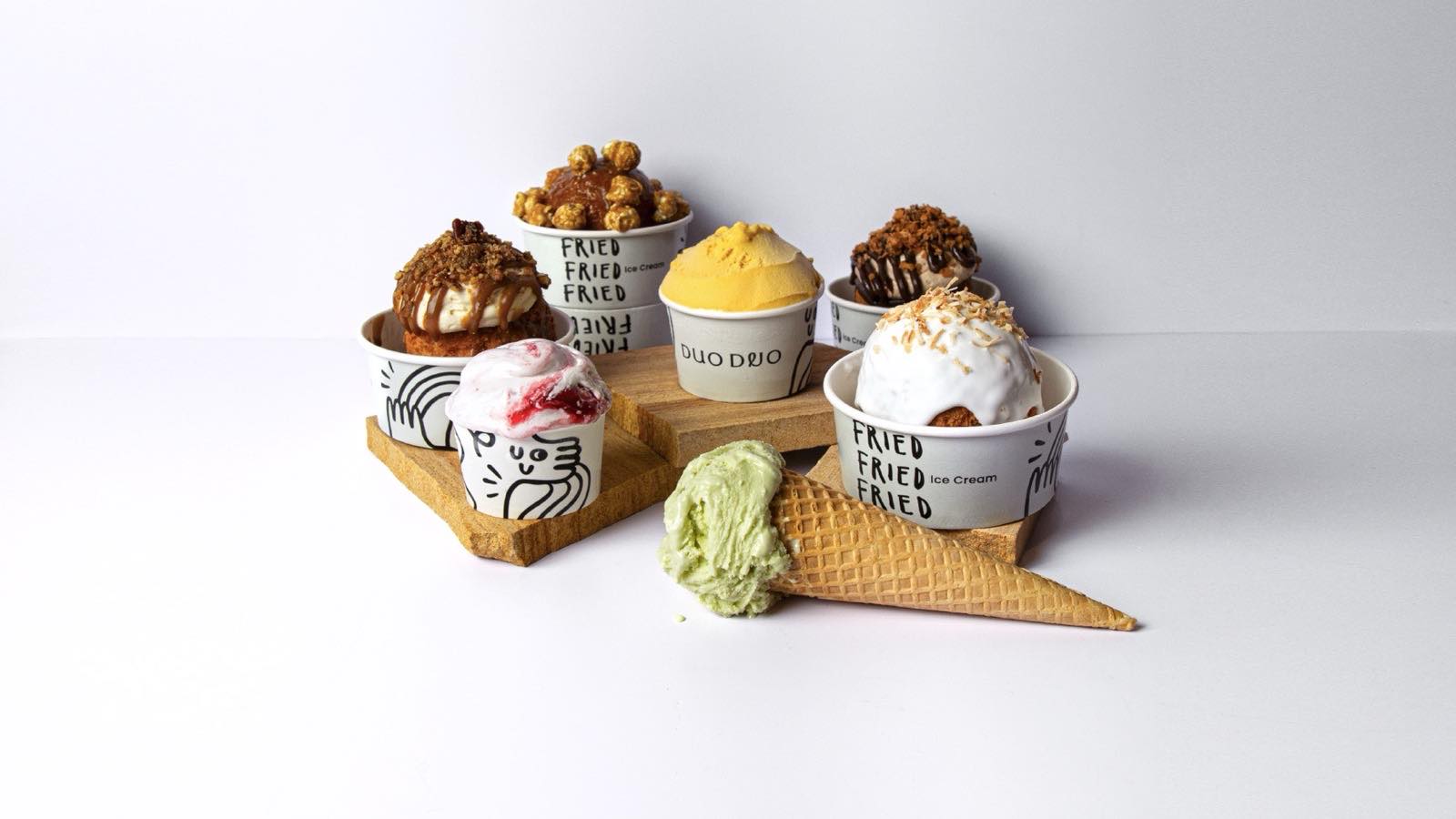 Duo Duo's line-up on timber stands: deep-fried ice cream in 'Fried Fried Fried' cups, mango and berry-ripple gelato, and a pistachio cone.