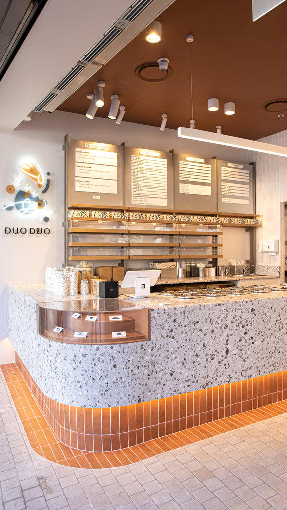 Inside Duo Duo Strathfield: a long terrazzo counter on a terracotta-tiled base, with menu boards above.